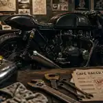 Moto cafe racer noire carbone : café racer en atelier, guidon bracelets, échappement mégaphone